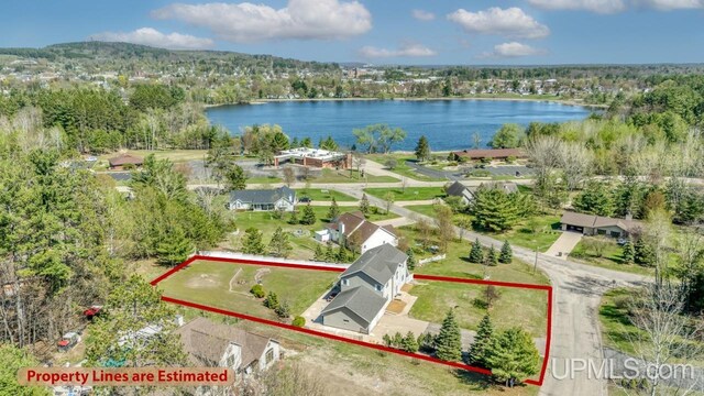 1000 N Evergreen Dr, Iron Mountain, MI 49801 - aerial overview of property's location featuring a large body of water, property boundaries highlighted, and a heavily wooded area