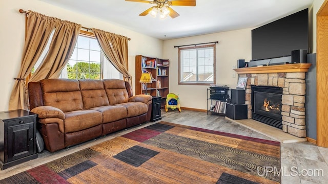 1000 N Evergreen Dr, Iron Mountain, MI 49801 - living room with healthy amount of natural light, a ceiling fan, baseboards, and a stone fireplace