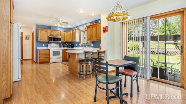1000 N Evergreen Dr, Iron Mountain, MI 49801 - kitchen with white appliances, a sink, a peninsula, light wood-type flooring, and recessed lighting
