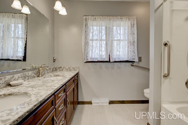8962 Stagecoach Q.5 Ave, Gladstone, MI 49837 - bathroom with baseboards, healthy amount of natural light, double vanity, and a bathtub