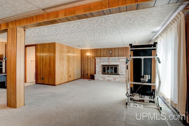 8962 Stagecoach Q.5 Ave, Gladstone, MI 49837 - unfurnished living room featuring carpet, a fireplace, and wood walls