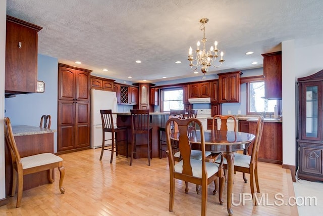 8962 Stagecoach Q.5 Ave, Gladstone, MI 49837 - dining space featuring a chandelier, recessed lighting, light wood-type flooring, and a textured ceiling
