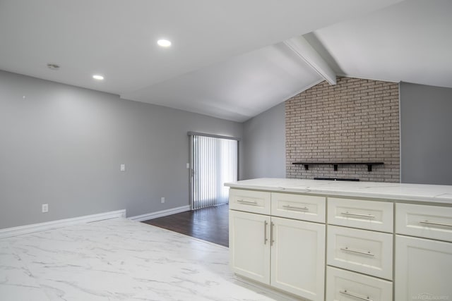 kitchen with light stone countertops, white cabinetry, dark marble finish flooring, and recessed lighting