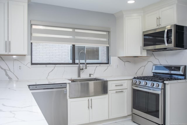kitchen with stainless steel appliances, a sink, white cabinetry, tasteful backsplash, and recessed lighting