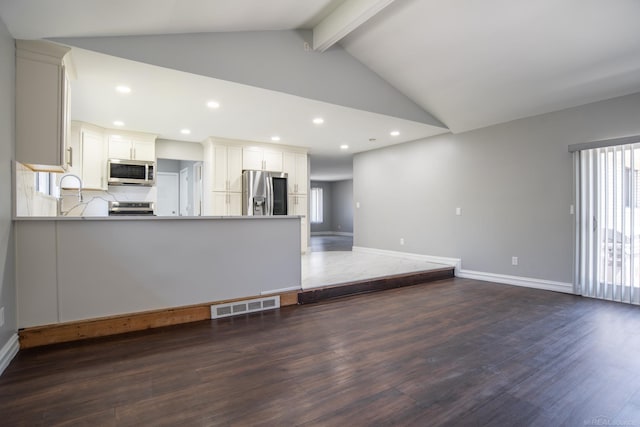 unfurnished living room featuring dark wood-style flooring, recessed lighting, a sink, and baseboards