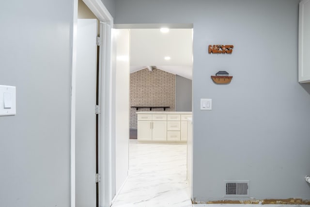 hall with lofted ceiling and light marble finish flooring