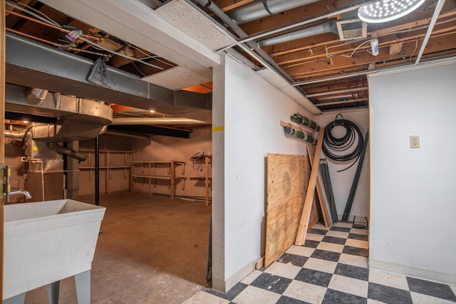 unfinished basement featuring tile patterned floors and a sink