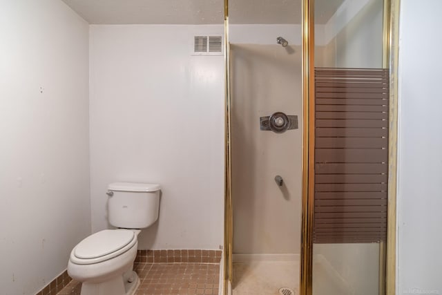 bathroom featuring a shower stall, toilet, and baseboards