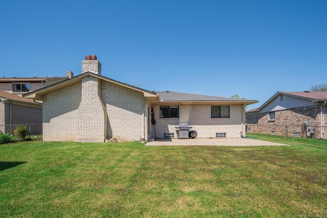 back of property with a patio, brick siding, and a chimney