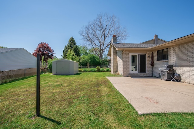 view of yard with a shed, a patio, and an outbuilding