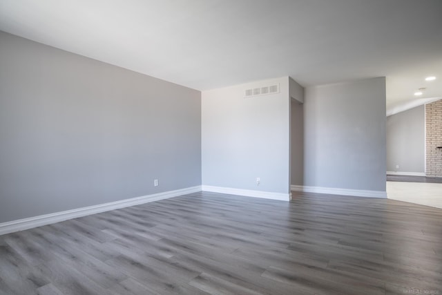 empty room with wood finished floors, baseboards, recessed lighting, and a fireplace