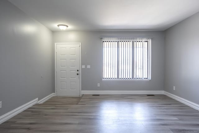 spare room with wood finished floors and baseboards
