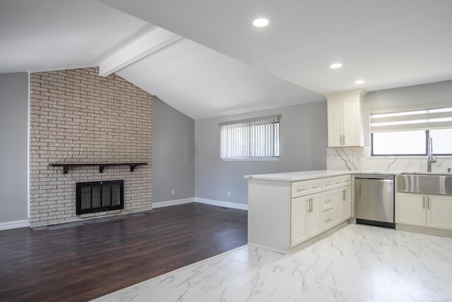 kitchen featuring dishwasher, a sink, a peninsula, white cabinetry, and light countertops