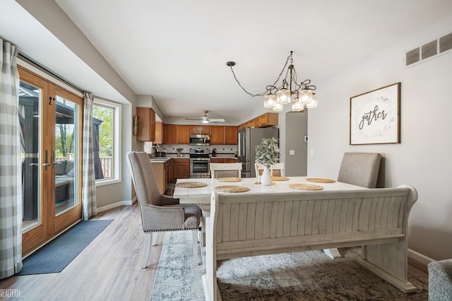 35657 Pierce St, Richmond, MI 48062 - dining space with light wood-style floors, baseboards, a ceiling fan, and a chandelier