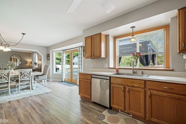 35657 Pierce St, Richmond, MI 48062 - kitchen with stainless steel dishwasher, a sink, light wood-style floors, brown cabinets, and pendant lighting