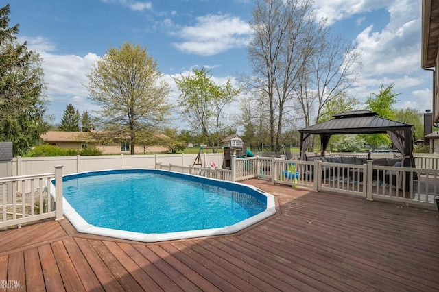 35657 Pierce St, Richmond, MI 48062 - view of swimming pool with a playground, a gazebo, a deck, and fence