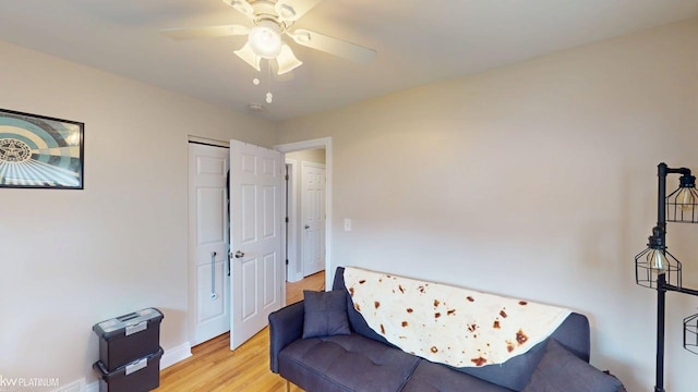 sitting room featuring light wood-type flooring, a ceiling fan, and baseboards