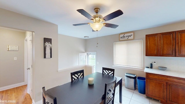dining space with ceiling fan and baseboards