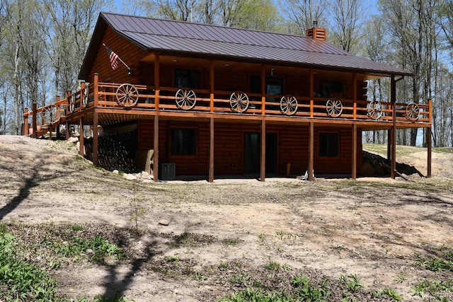 1322 W Northwoods Ln, Hardwood, MI 49834 - rear view of house featuring log exterior, a chimney, a wooden deck, and metal roof