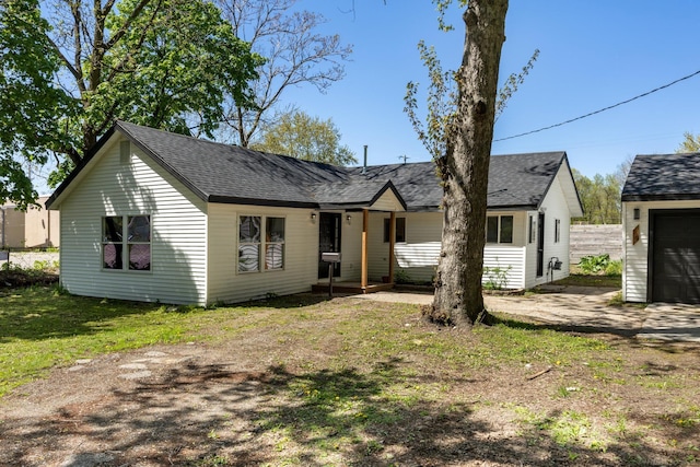 view of front facade featuring a shingled roof and fence