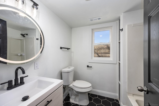 bathroom with tile patterned floors, toilet, vanity, and a shower