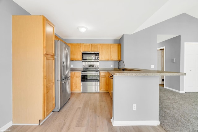 51663 Hale Ln, Chesterfield, MI 48051 - kitchen featuring appliances with stainless steel finishes, a peninsula, light countertops, vaulted ceiling, and light wood-style floors