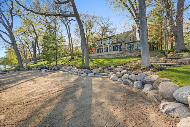 view of home's community featuring a patio area and a lawn