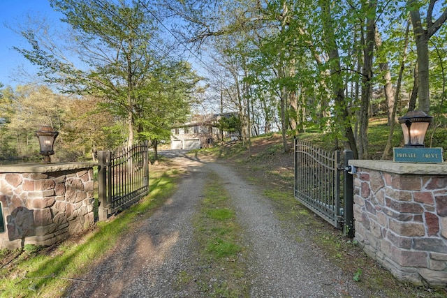 view of dirt / gravel road with a gate and a gated entry
