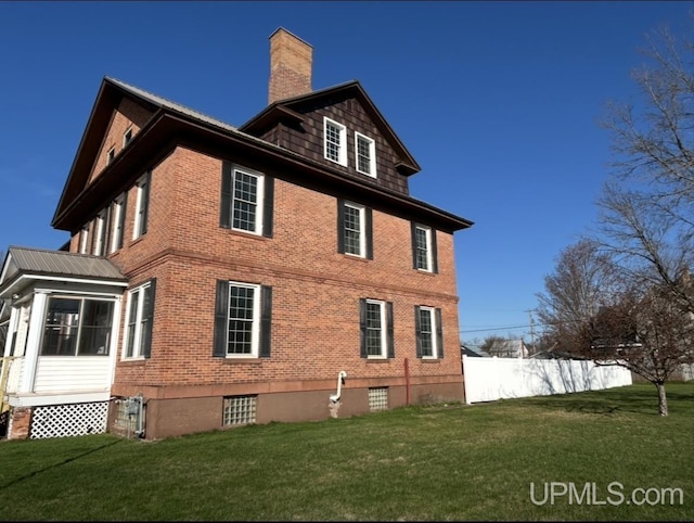 258 W Jasper St, Gwinn, MI 49841 - view of property exterior featuring brick siding, a chimney, and a sunroom