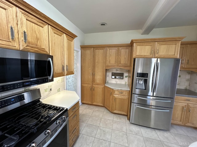 258 W Jasper St, Gwinn, MI 49841 - kitchen with appliances with stainless steel finishes, backsplash, beam ceiling, brown cabinets, and light countertops