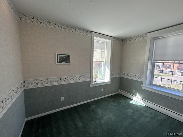 258 W Jasper St, Gwinn, MI 49841 - spare room with a baseboard heating unit, plenty of natural light, wallpapered walls, dark colored carpet, and a wainscoted wall
