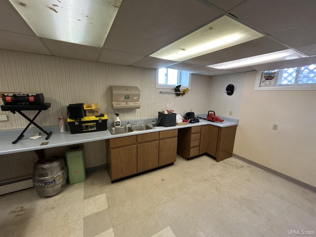 258 W Jasper St, Gwinn, MI 49841 - kitchen featuring brown cabinetry, a paneled ceiling, light countertops, a sink, and a baseboard radiator