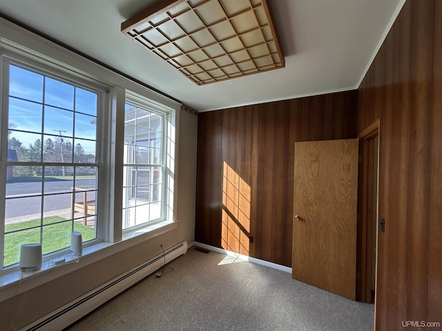 258 W Jasper St, Gwinn, MI 49841 - unfurnished room with baseboard heating, plenty of natural light, wood walls, and baseboards