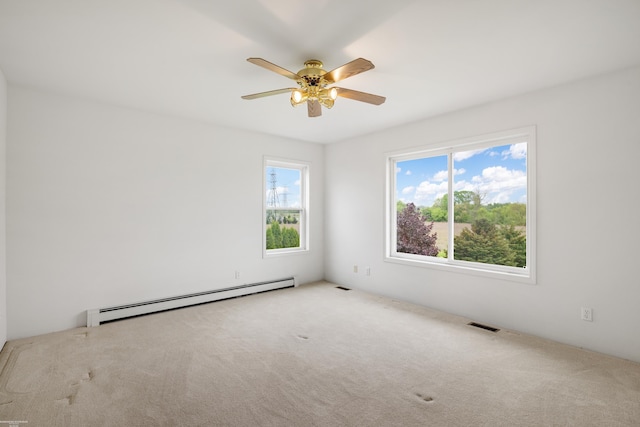 carpeted spare room with baseboard heating and a ceiling fan