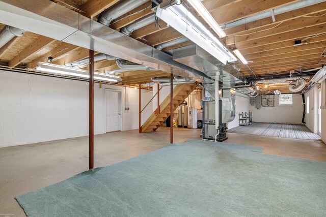 basement featuring stairway, water heater, heating unit, and electric panel