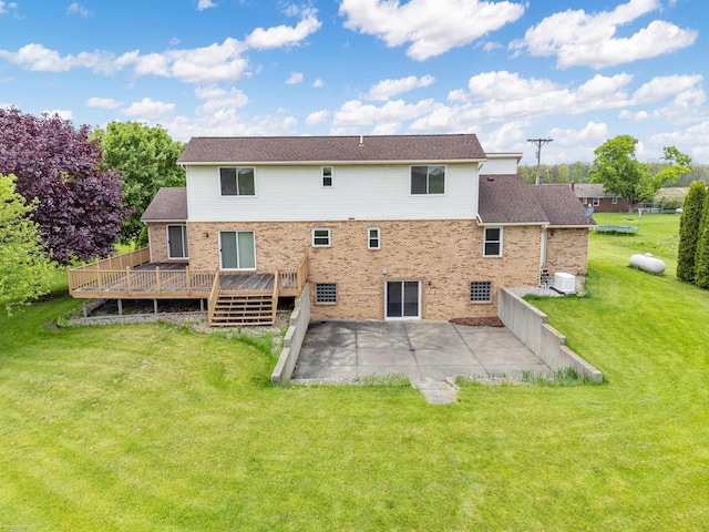 back of house featuring a patio, a wooden deck, brick siding, and a lawn