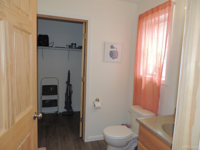8653 Ll Rd, Rapid River, MI 49878 - bathroom featuring toilet, wood finished floors, vanity, and baseboards