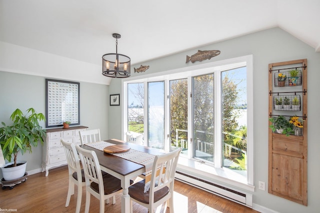 2758 Military St, Port Huron, MI 48060 - dining space featuring baseboard heating, a chandelier, vaulted ceiling, wood finished floors, and baseboards