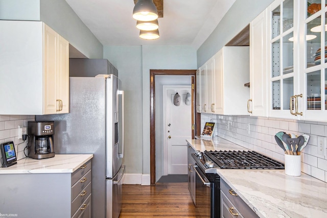 2758 Military St, Port Huron, MI 48060 - kitchen featuring appliances with stainless steel finishes, light stone counters, dark wood-style floors, backsplash, and baseboards