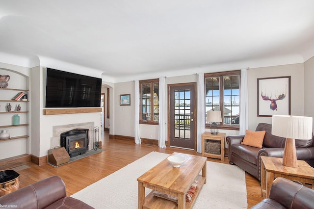 2758 Military St, Port Huron, MI 48060 - living area with light wood-type flooring, a lit fireplace, and baseboards