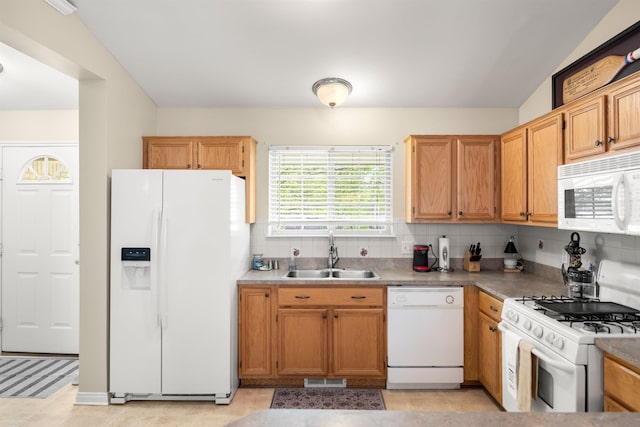 kitchen featuring white appliances, a sink, and tasteful backsplash