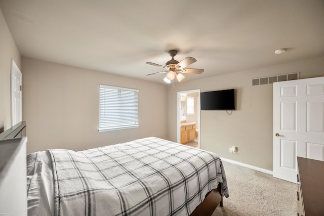 carpeted bedroom featuring baseboards, a ceiling fan, and ensuite bath