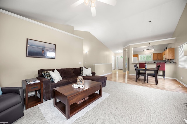 living area with lofted ceiling, ceiling fan, baseboards, and light wood finished floors