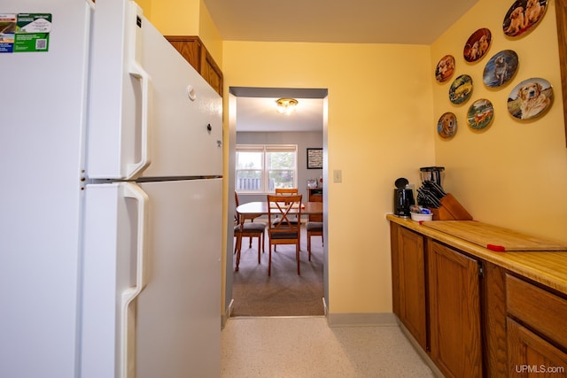 405 Mustang St, Gwinn, MI 49841 - kitchen with freestanding refrigerator, brown cabinets, and light countertops