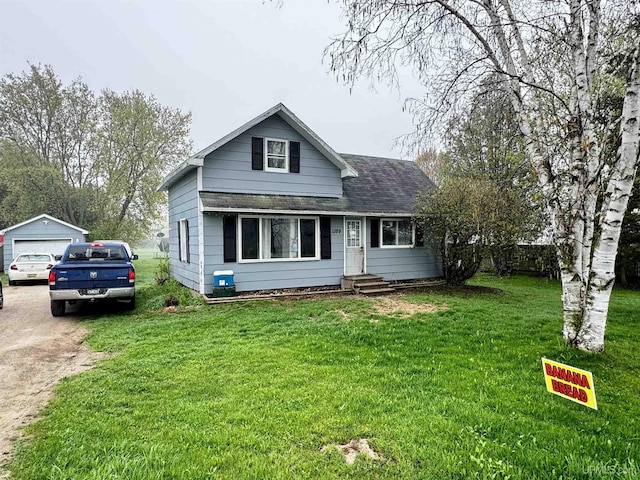 1389 15.5 Rd, Bark River, MI 49807 - view of front of property featuring a garage, a front yard, an outdoor structure, and a shingled roof