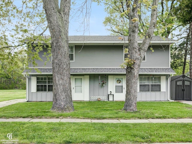 view of front of property featuring a storage shed, a front lawn, an outdoor structure, and roof with shingles