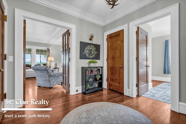 entryway with radiator heating unit, crown molding, wood finished floors, baseboards, and french doors