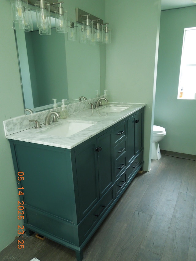 1582 Oakwood St, Gladwin, MI 48624 - full bathroom with wood finished floors, toilet, and double vanity