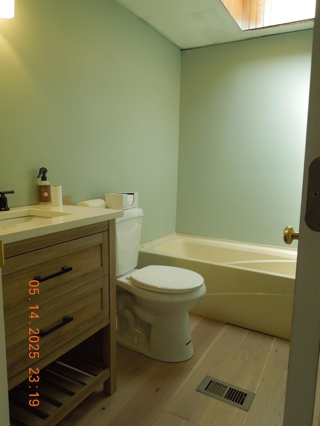 1582 Oakwood St, Gladwin, MI 48624 - full bath featuring wood finished floors, toilet, a tub to relax in, and vanity