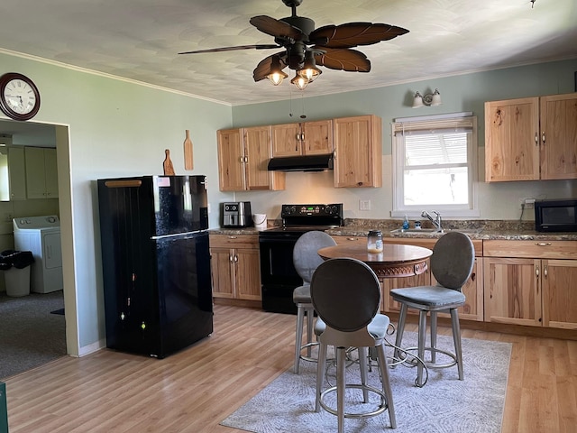 kitchen featuring black appliances, washer / dryer, under cabinet range hood, a sink, and ceiling fan